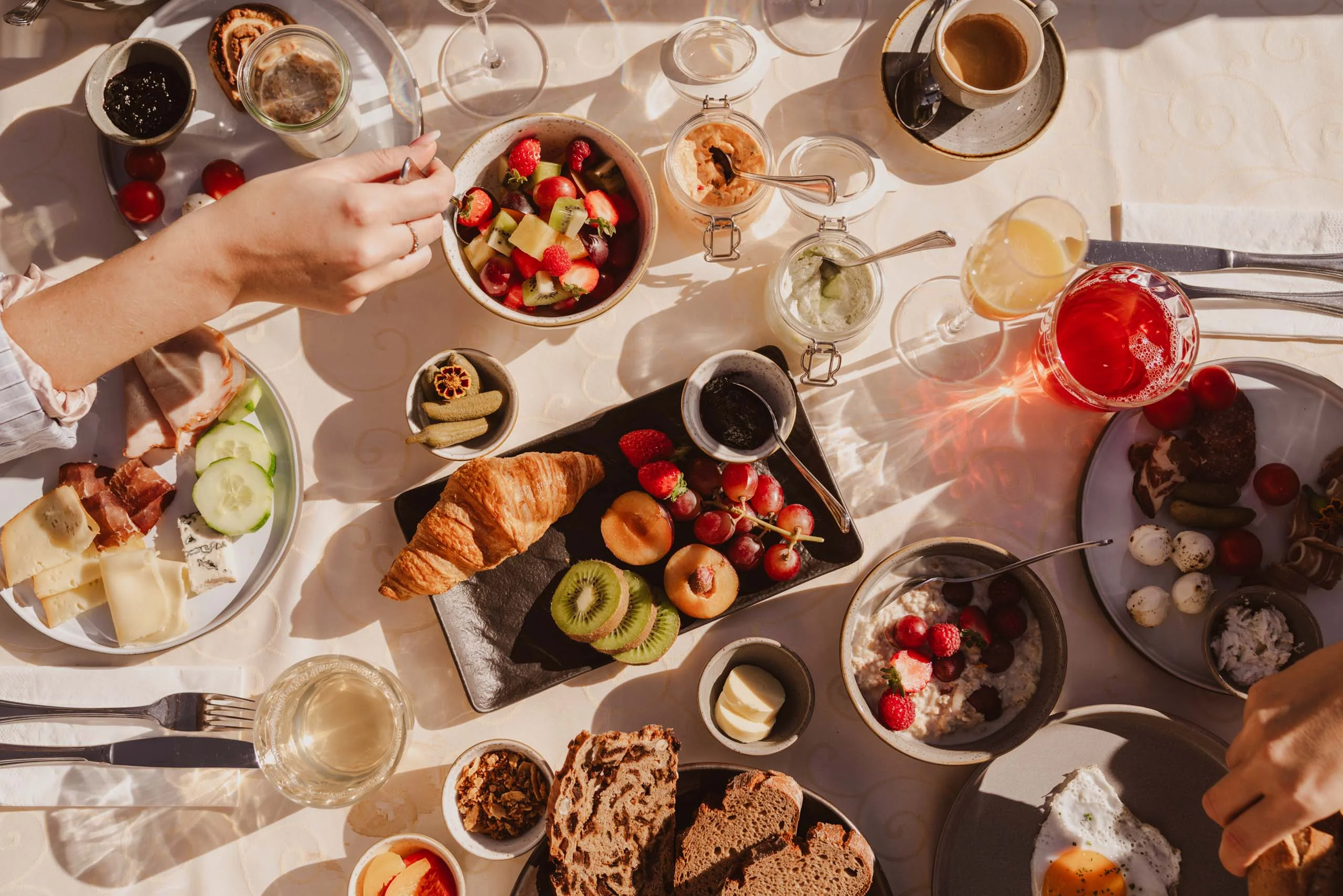 Ein Hotel in Großarl für Aktive | für Genießer | für dich Verschiedene Frühstücksgerichte mit Obst, Croissant, Kaffee und Eiern auf einem Tisch