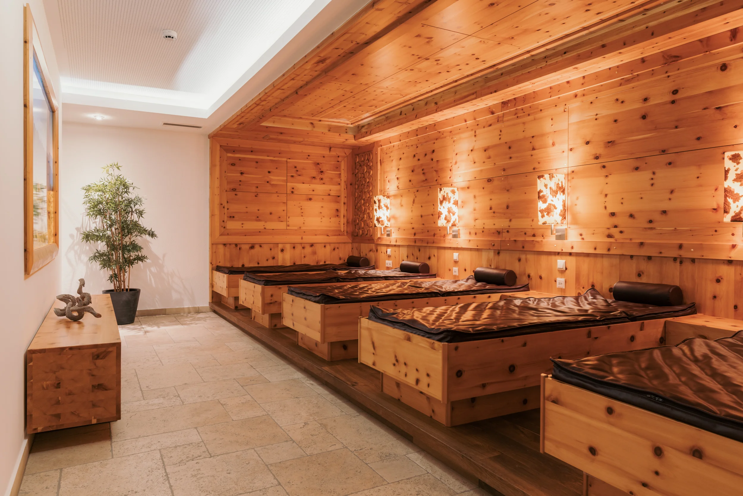 Ein Hotel in Großarl für Aktive | für Genießer | für dich Ruheraum mit Holzwänden und Liegen im Wellnessbereich